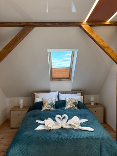 a bedroom with a bed with two white towels at Apartament Wypoczynkowy Centrum in Tuchola