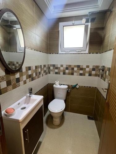 a bathroom with a toilet and a sink and a mirror at Studio de vacance à louer in Monastir