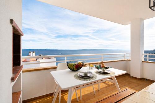 a table and chairs on a balcony with a view of the ocean at Vista Roses Mar - Ariadna in Roses
