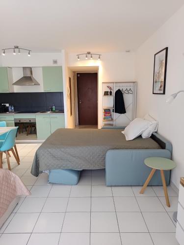 a bedroom with a large bed and a kitchen at Nice studio 5 minutes walk from the beach in Cagnes-sur-Mer
