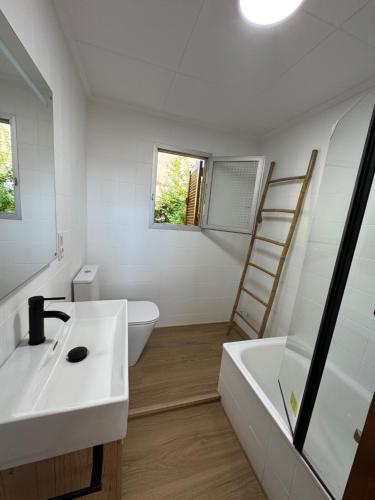 a bathroom with a sink and a toilet and a ladder at El refugio de NaRo in Chella