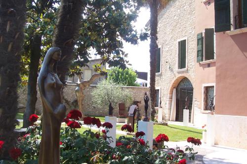 a statue of a woman in a garden with flowers at Residence Villa Vinco in Tregnago