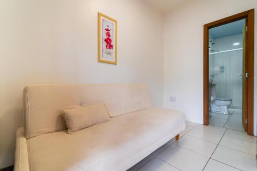 a couch in a living room with a bathroom at Hotel Brasil in Penha