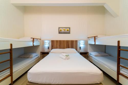 two beds in a room with two bunk beds at Hotel Brasil in Penha