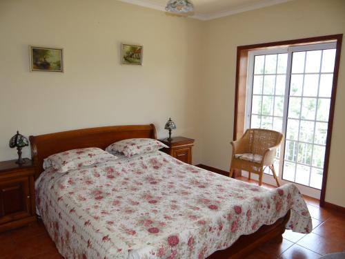 a bedroom with a bed with a flowered comforter at Casa do Tamega in Amarante