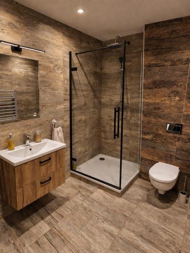 a bathroom with a shower and a sink and a toilet at Apartmány Bojnický Vínny Dom in Bojnice