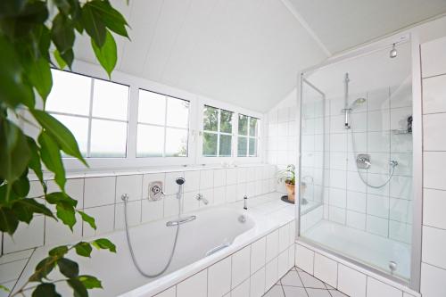 uma casa de banho branca com uma banheira e um chuveiro em Alte seester Schule em Westerkappeln