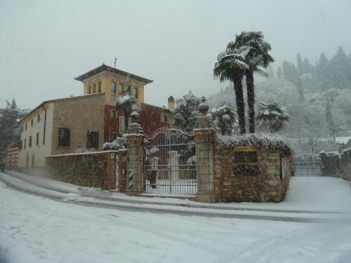 a fence in front of a building in the snow at Residence Villa Vinco in Tregnago