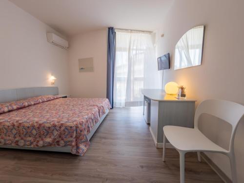 a bedroom with a bed and a desk and a chair at Hotel Park Spiaggia in Grado