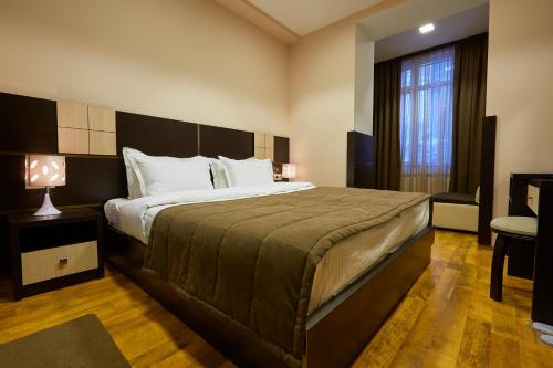 a bedroom with a large bed and a window at Hotel Lilia Yerevan in Yerevan