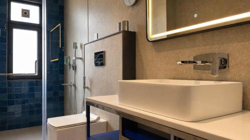 a bathroom with a white sink and a toilet at Zone by The Park Darjeeling in Darjeeling