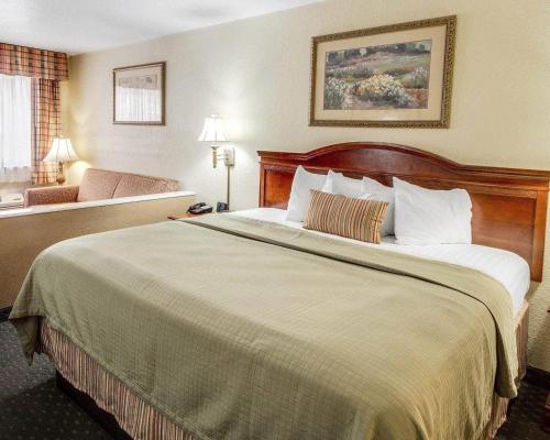 a hotel room with a large bed and a couch at Econo Lodge Inn & Suites Eagle Pass in Eagle Pass