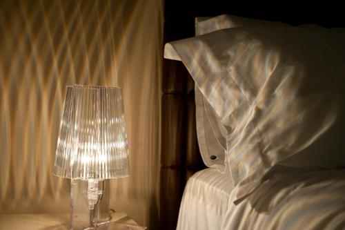 a lamp sitting on a table next to a bed at Casa Majore in Chiaramonte Gulfi