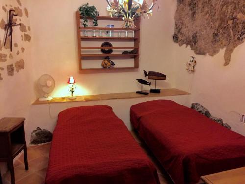 - 2 lits dans une chambre avec des draps rouges dans l'établissement Apartment Maison La Roche, à Peyriac-de-Mer