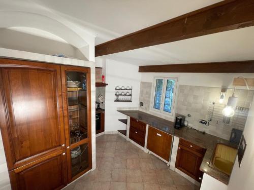a kitchen with wooden cabinets and a counter top at La villetta tra ulivi e colline in Civezza