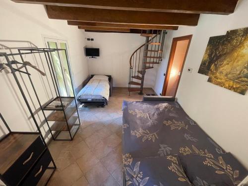a room with a bed and a staircase in it at La villetta tra ulivi e colline in Civezza