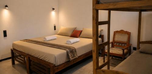 a bedroom with two bunk beds and a chair at FS Hotel & villa in Arugam Bay