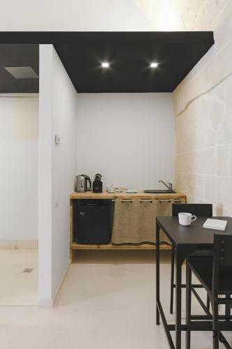a kitchen with a table and a counter at Hydria Rooms in Matera
