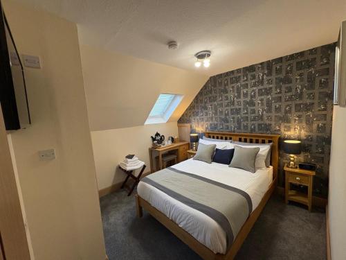 a bedroom with a large bed and a wall at Kildonan House Bed and Breakfast in Corpach