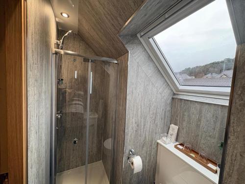 a bathroom with a shower and a skylight at Kildonan House Bed and Breakfast in Corpach