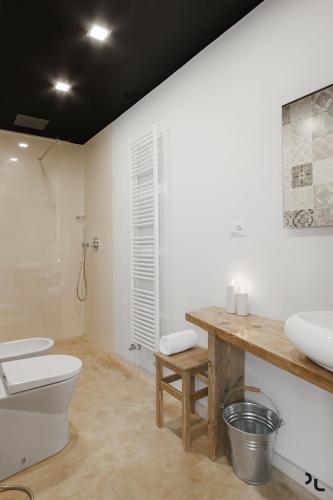 a bathroom with a white toilet and a sink at Hydria Rooms in Matera