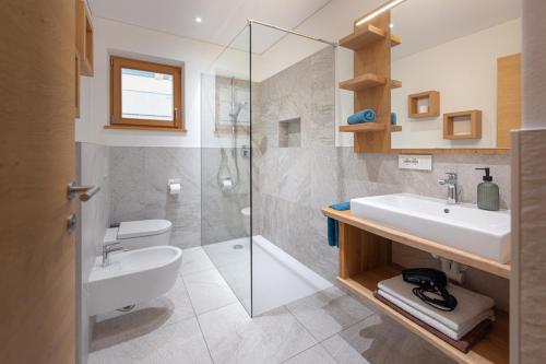 a bathroom with a sink and a glass shower at Schmalzlhof in Siusi