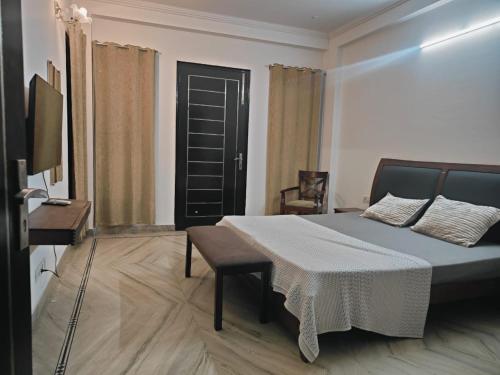 a bedroom with a bed and a table and a television at Home By The Park in New Delhi