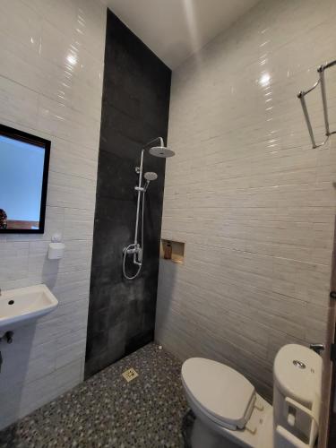 a bathroom with a toilet and a sink and a shower at Pondok Ashanara Sading in Sempidi
