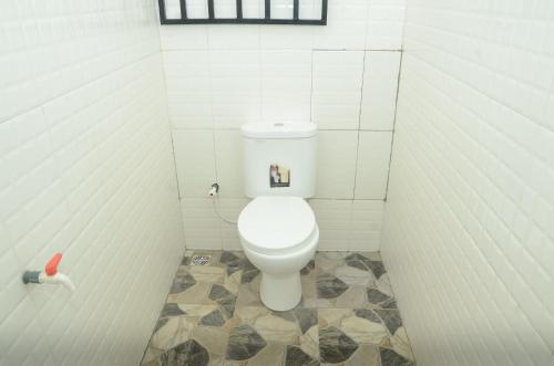 a bathroom with a white toilet in a stall at Besta Apartments in Akure