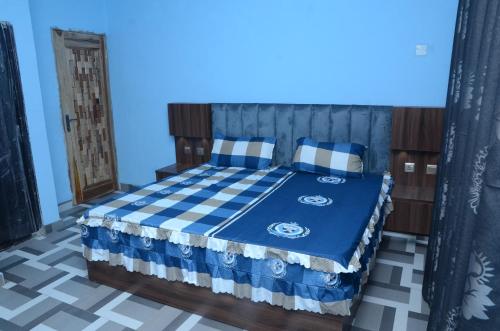a bedroom with a bed with a blue and white bedspread at Besta Apartments in Akure