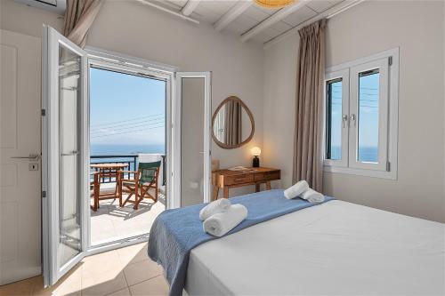 a bedroom with a bed and a view of the ocean at To Pelagos in Agios Sostis