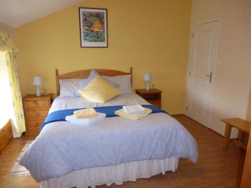 a bedroom with a bed with two towels on it at L'Hirondelle Chambres d'Hotes in Saint-Mathieu