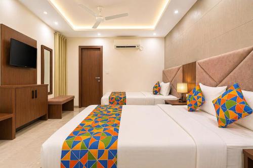 a hotel room with two beds and a television at Hotel Mahadev Palace in Kankhal
