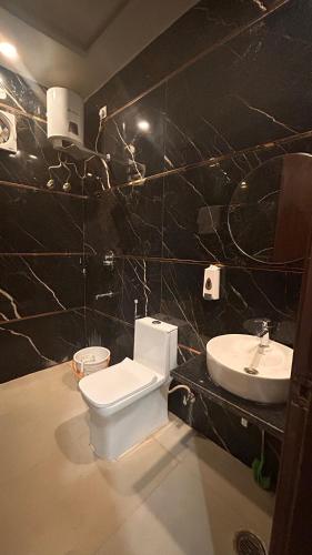 a bathroom with a toilet and a sink at Hotel Mahadev Palace in Kankhal