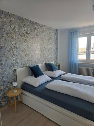 a bedroom with a bed with blue and white pillows at Ferienwohnung Weitblick in Dachau