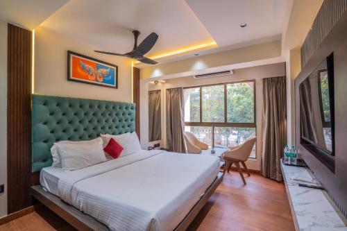 a bedroom with a large bed and a large window at Mosaic Go Star Grand in Navi Mumbai