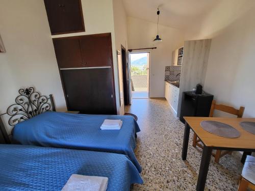 a room with two beds and a table and a kitchen at Filippos Apartments "Room 6" in Spartià