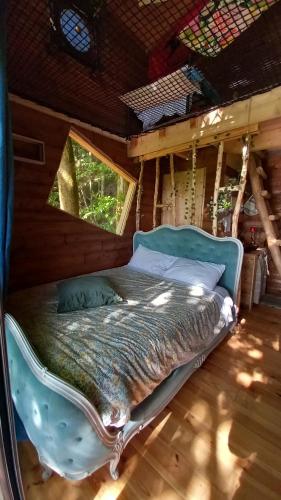 a bed in the back of a room with windows at Cabane du Druide Domaine de Fangorn in Glux