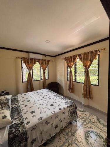 a bedroom with a bed and two windows at Linas Lodge in Vaitele