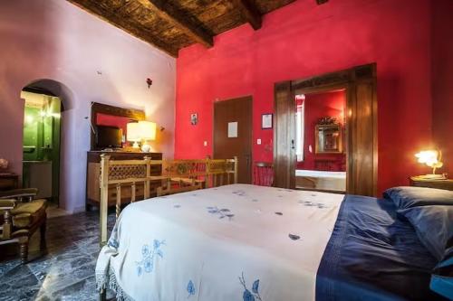 ein Schlafzimmer mit einem großen Bett und roten Wänden in der Unterkunft Casamuseo del Risorgimento in Lungro