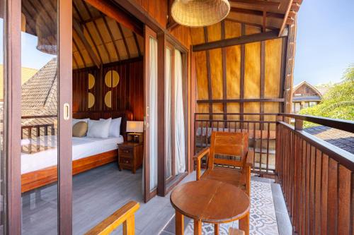 a room with a bed and a table on a balcony at Cove Dadeka in Canggu