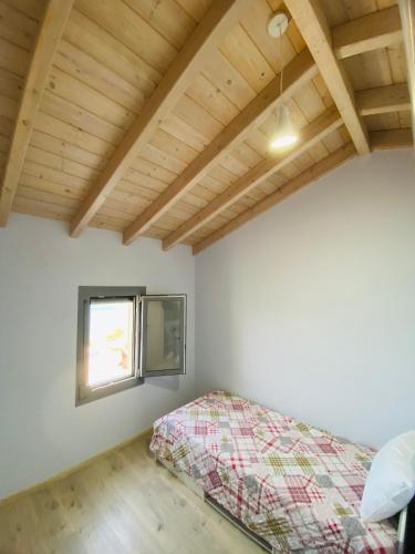 a bedroom with a bed and a window at Athos view house in Agios Ioannis Kaspaka