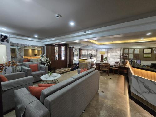 a large living room with couches and a table at Ralph Anthony Suites Hotel in Manila