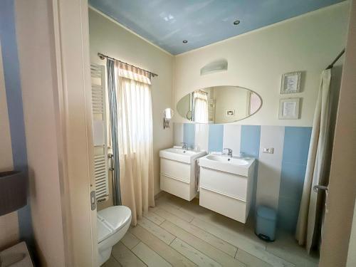 a bathroom with a toilet and a sink and a mirror at Sonomusica B&B in Gazzola Di Rivalta