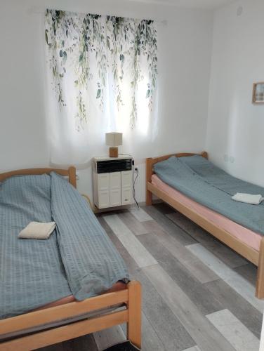 a bedroom with two beds and a window at House&mini-Camp SKELICA in Neštin