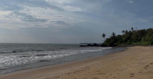 a beach with footprints in the sand and the ocean at beach homestay sea view in Kannur