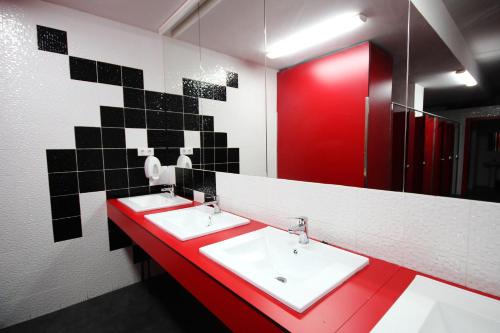 łazienka z 2 umywalkami i czerwonym blatem w obiekcie Botxo Gallery - Youth Hostel Bilbao w mieście Bilbao