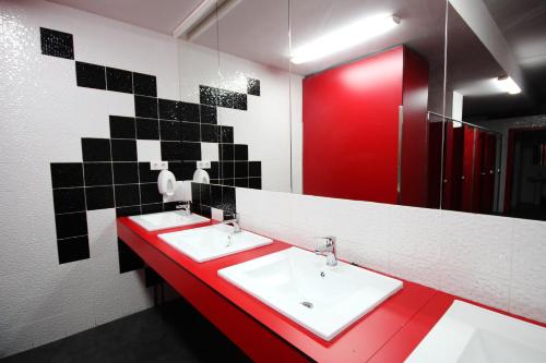 baño con 2 lavabos y encimera roja en Botxo Gallery - Youth Hostel Bilbao, en Bilbao