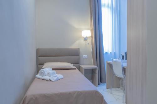 a bedroom with a bed with towels on it at Le Suite in Crotone