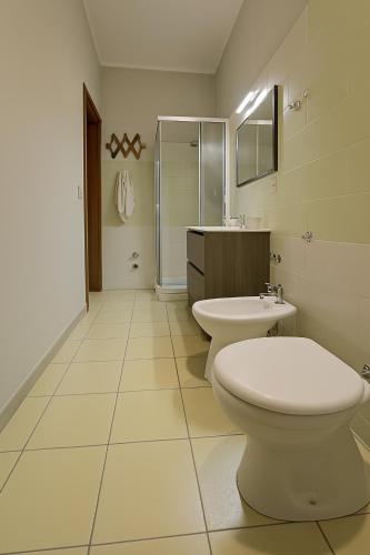 a white bathroom with a toilet and a sink at Villa Lesina Casa Vacanze in Santa Maria di Castellabate